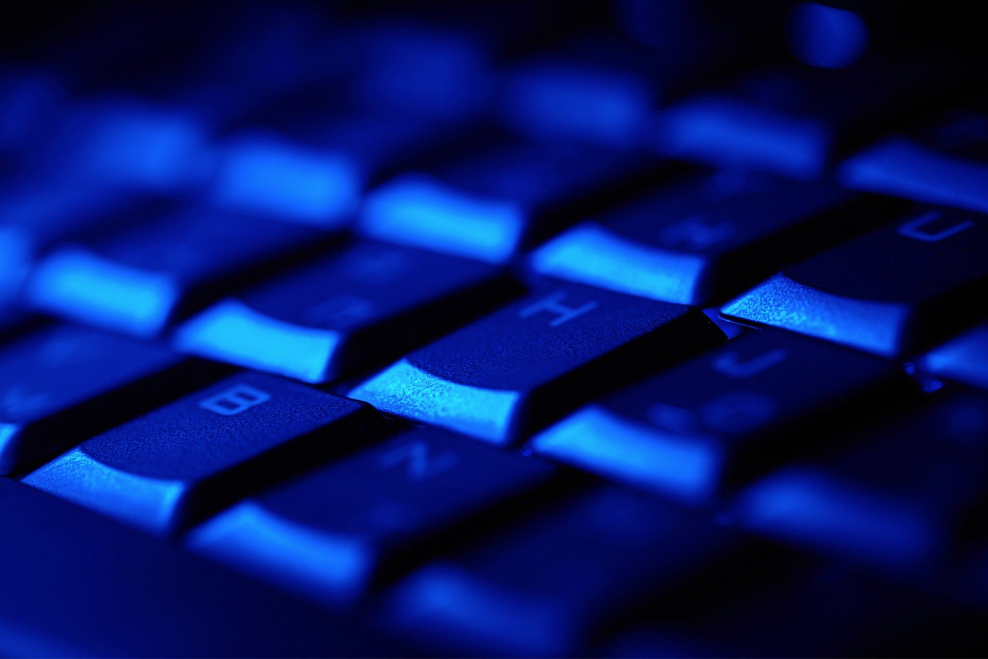 A close up of a computer keyboard with blue keys
